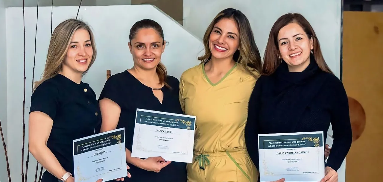 Cristina Gómez con tres alumnas que muestran su certificado de mesoterapia